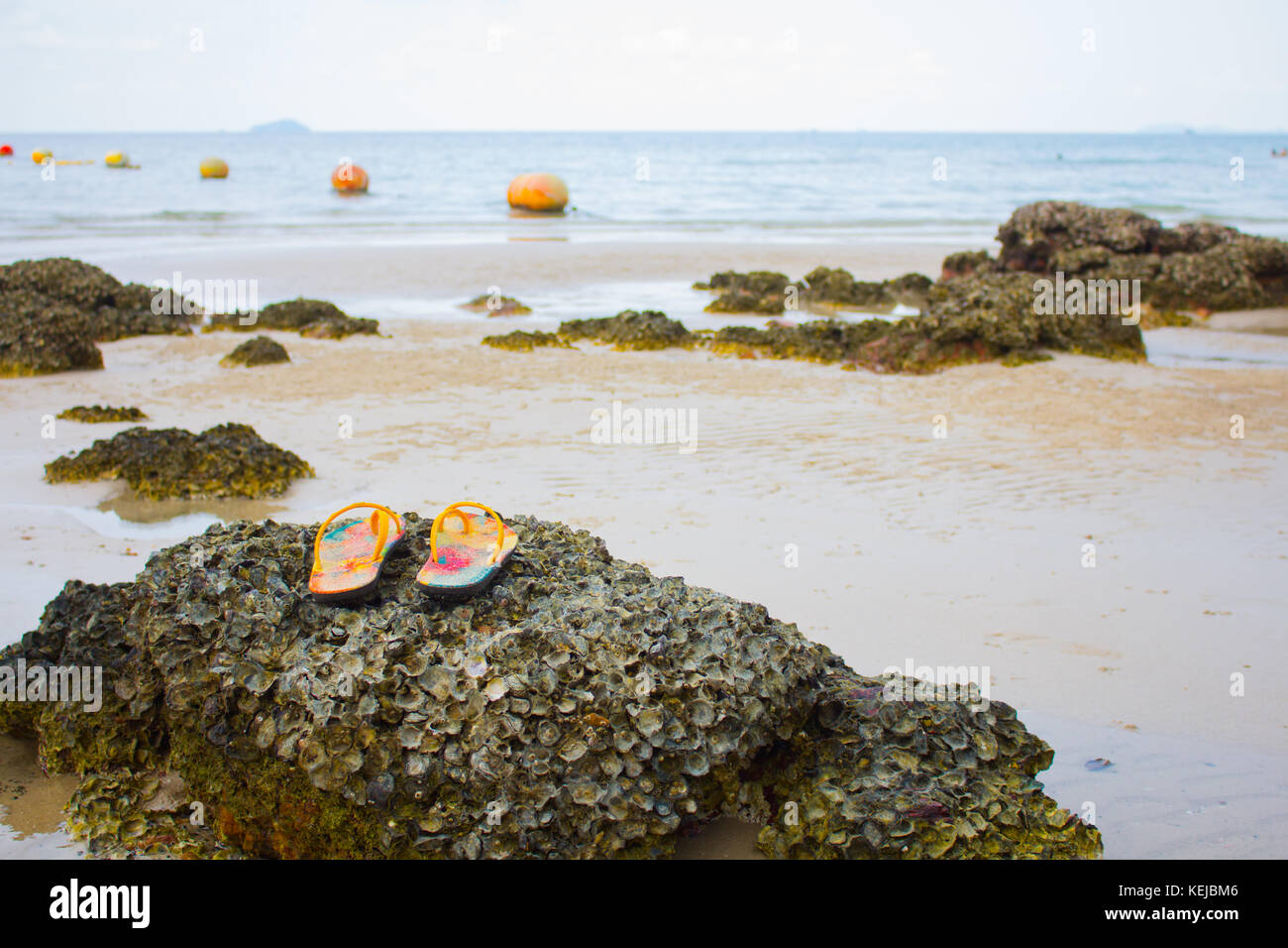 Scarpe su pietra in spiaggia, sullo sfondo del mare Foto Stock