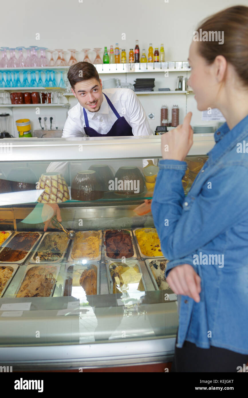 Cameriere che serve gelati a donna in gelateria Foto Stock