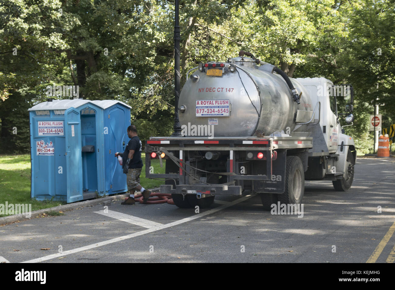 Il lavoratore di un'azienda di servizi igienici portatile pulisce i rifiuti in un luogo a Prospect Park, Brooklyn, New York. Foto Stock