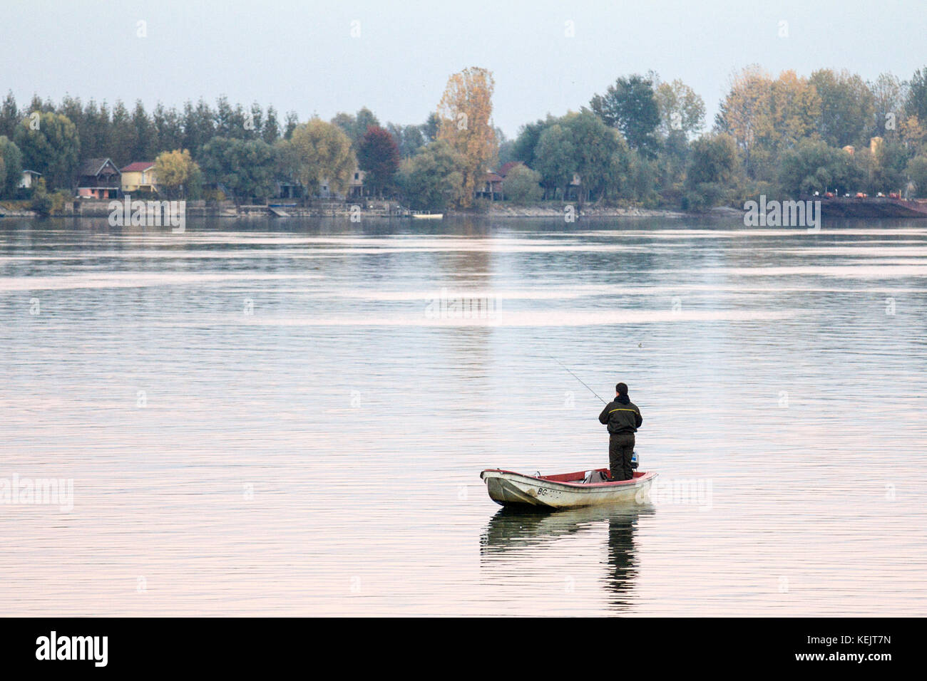 A Belgrado, in Serbia - ottobre 22, 2016 pescatore di pesca sul fiume Danubio sulla sua barca a remi durante un caldo pomeriggio d'autunno a zemun, una northern distr Foto Stock