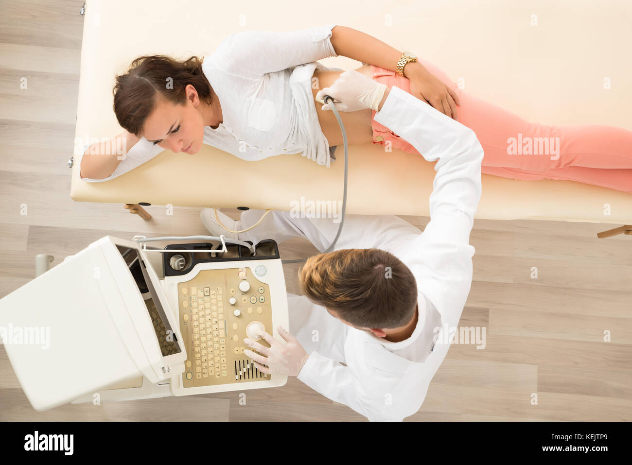 Il medico di sesso maschile di eseguire l'esame Sonogram in clinica Foto Stock