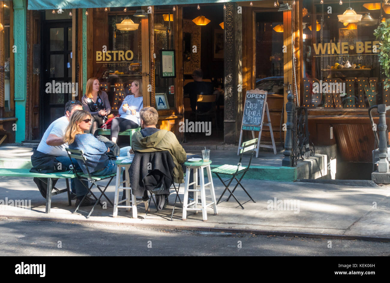 Giovani godendo il meteo alfresco al di fuori di un bistro SoHo e wine bar Foto Stock