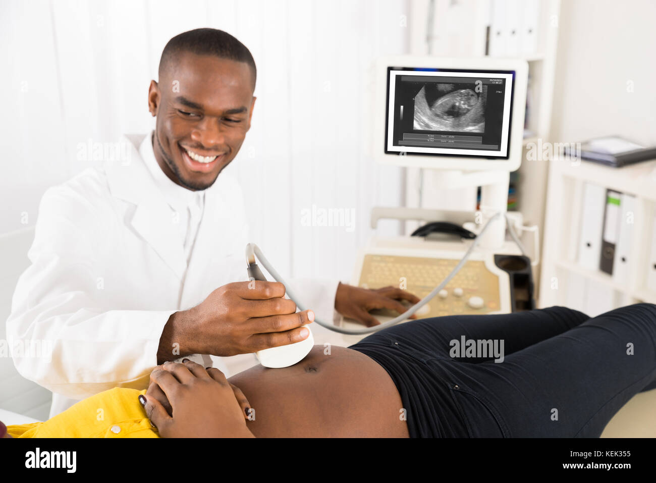 Ginecologo controllo della donna incinta, ventre con trasduttore a ultrasuoni in ospedale Foto Stock