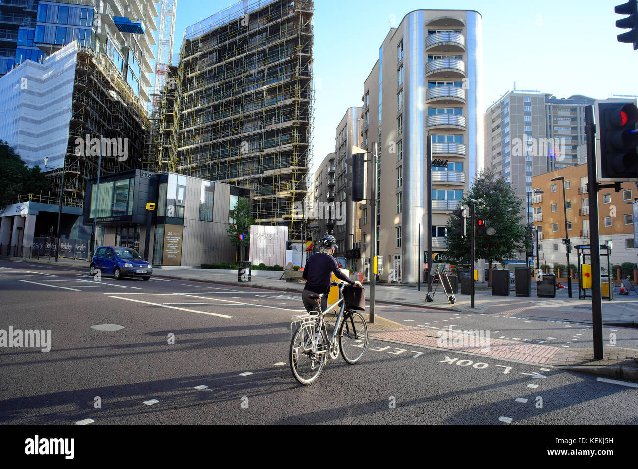 Ciclista passeggiate in bicicletta attraverso attraversamento pedonale su City Road, Londra, Inghilterra Foto Stock