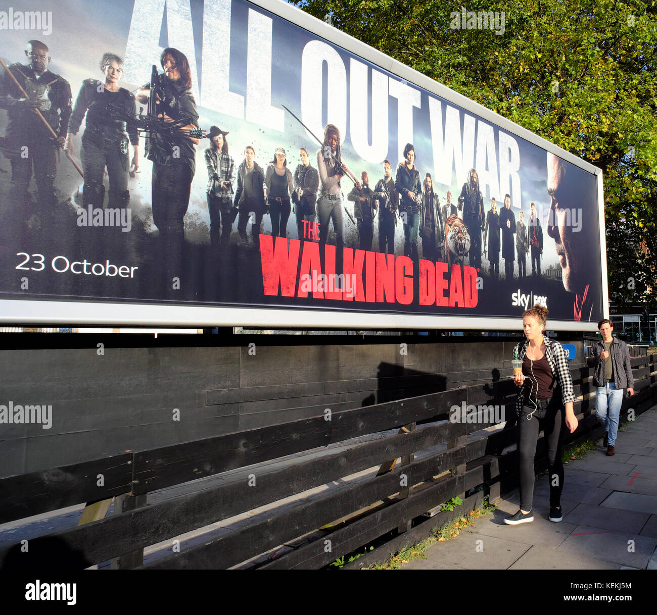 La gente camminare passato Il Walking Dead cartellone a Londra, Inghilterra Foto Stock