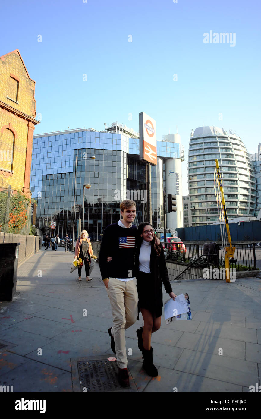 Sorridenti uomo caucasico & donna asiatica camminando con le braccia intorno a ogni altro a Londra in Inghilterra Foto Stock