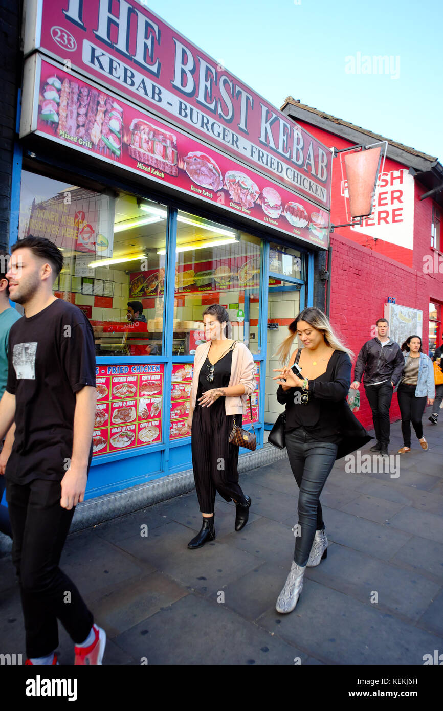 La gente camminare passato il miglior Kebab takeaway in Shoreditch, Londra, Inghilterra Foto Stock