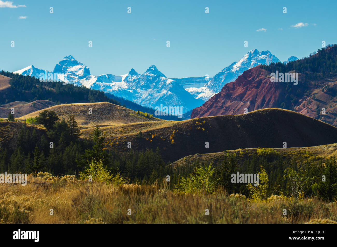 Il variegato paesaggio del Wyoming è rivelato in strati colorati di massa con la sempre presente Grand Teton Mountains, un lontano dalla parete distanti. Foto Stock