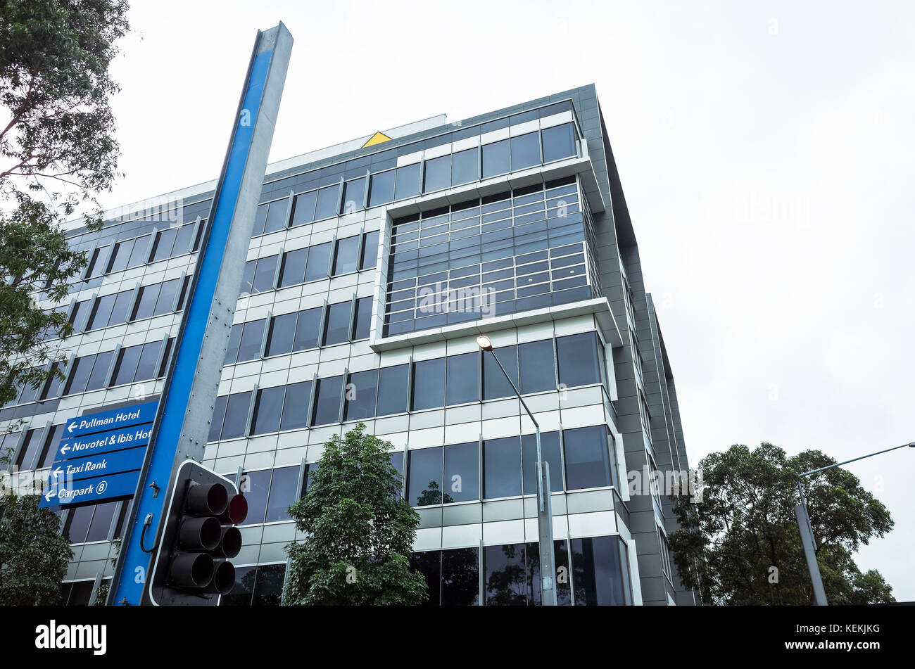 Edificio per uffici all'Olympic Park, Sydney, Australia. Esterno in vetro dell'edificio commerciale. Edificio commerciale all'angolo della strada con semafori, traf Foto Stock