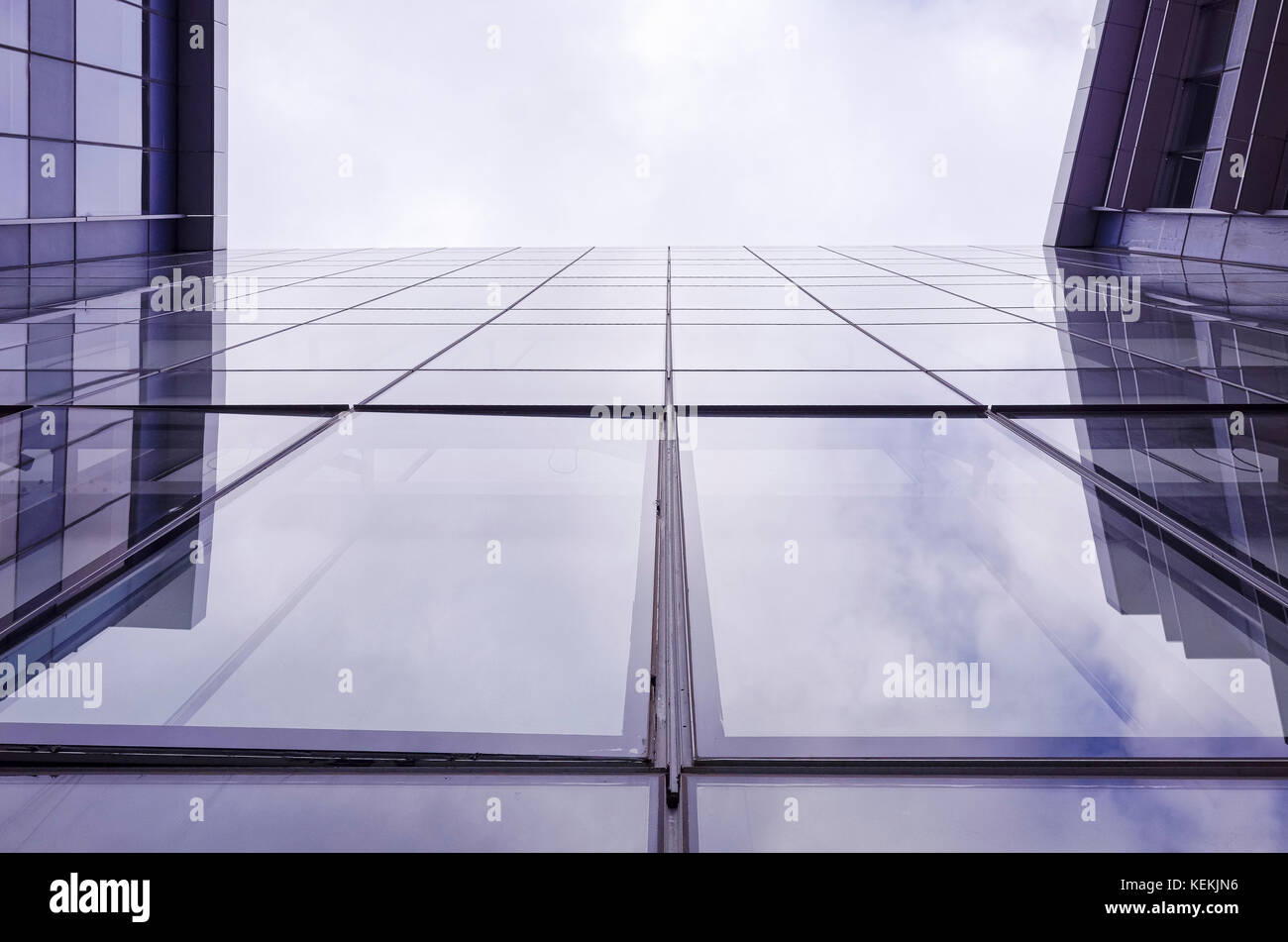 Cercando il vetro esterno dell edificio per uffici. parete in vetro di edificio commerciale riflette il cielo. primo piano della moderna architettura di vetro. Foto Stock