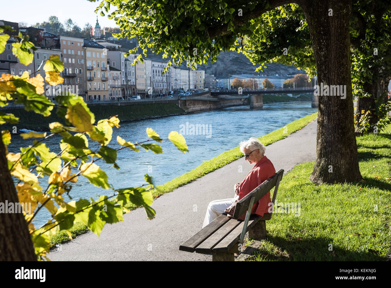 Salisburgo, eine ältere Frau sitzt an der Salzach - Salisburgo, Donna seduta presso le rive del fiume Salzach Foto Stock