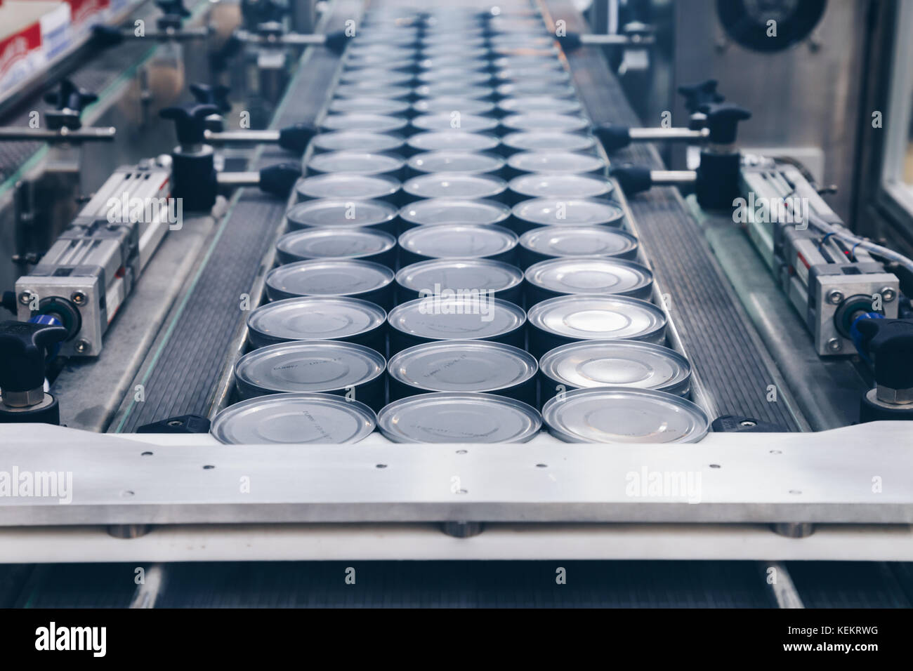 Le lattine di alluminio per alimenti trasformati in linea di fabbrica nastro macchina in corrispondenza delle conserve alimentari Fabbricazione, messa a fuoco selettiva e raffreddare il tono. Foto Stock