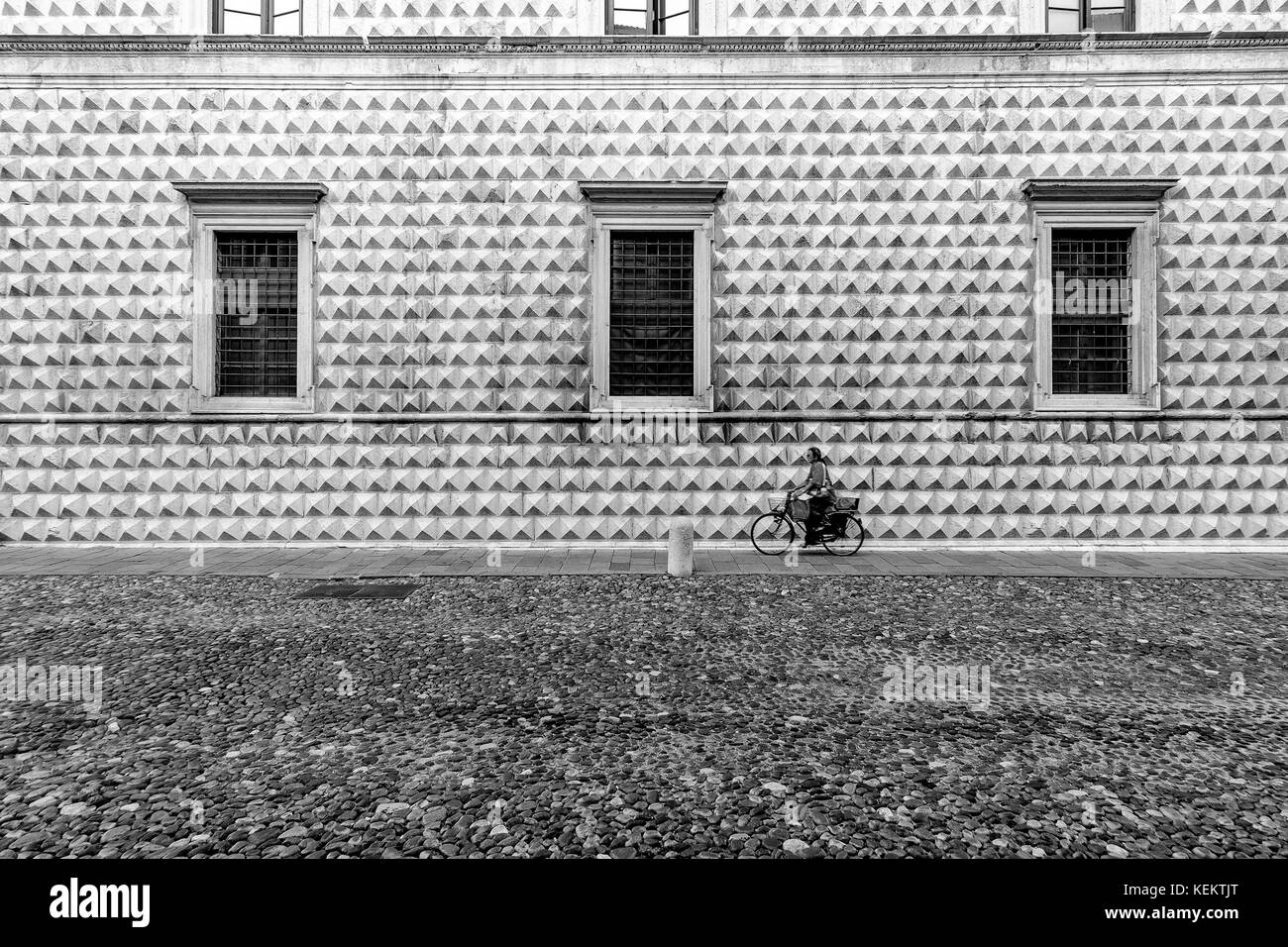 Ferrara, Italia - 21 agosto 2016. donna in bicicletta di fronte al famoso palazzo dei diamanti. Foto Stock