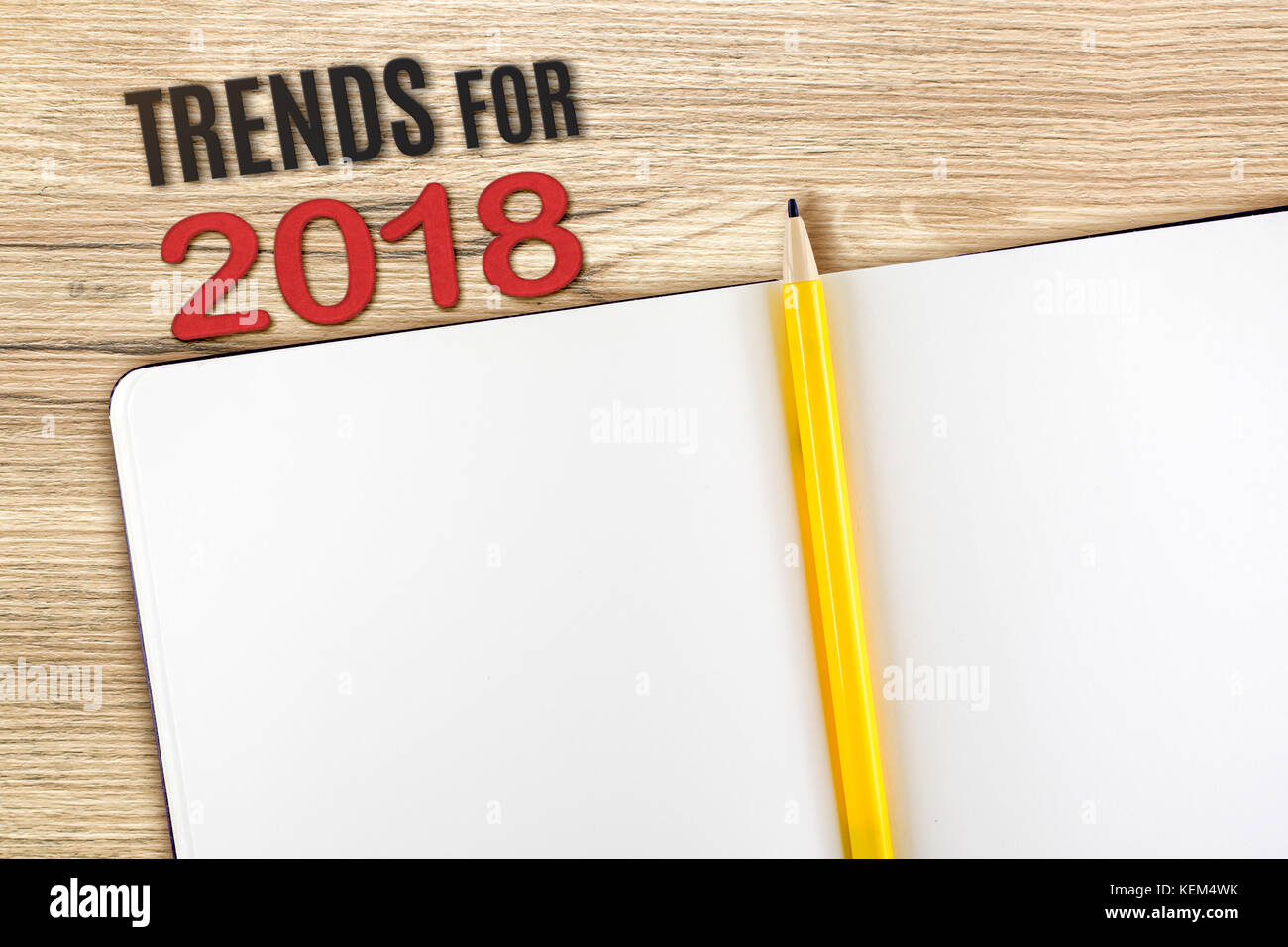 Vista superiore del 2018 tendenze con vuoto notebook aperto e matita gialla sul tavolo di legno alto,mock up per aggiungere i tuoi contenuti o di design Foto Stock