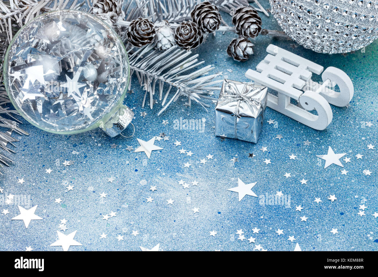 Abete bianco ramo di albero con coni e addobbi per l'albero su blu glitter sfondo con stelle scintillanti Foto Stock