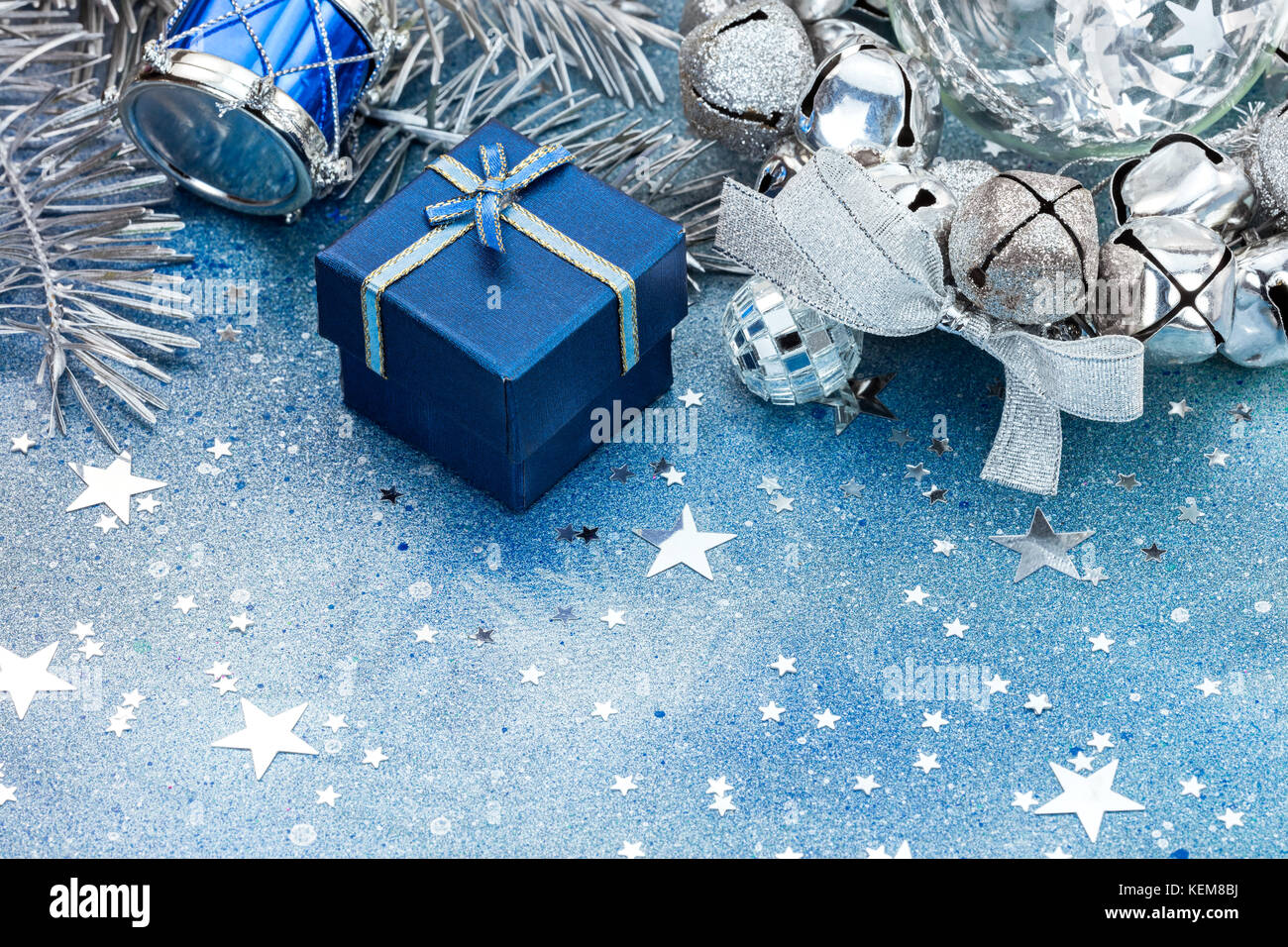 Albero di natale decorazioni blu su sfondo spumanti. Le sfere di argento, il tamburo e il piccolo blu confezione regalo. Foto Stock