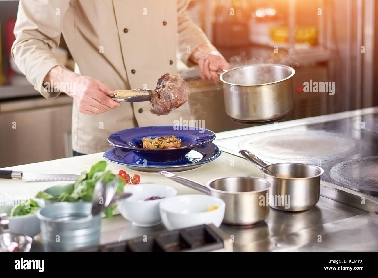 Lo chef mani agnello cotto codolo maschio chef mettendo sul gambo di agnello nella piastra con farcitura. Preparazione del gustoso piatto a livello europeo ristorante kit Foto Stock