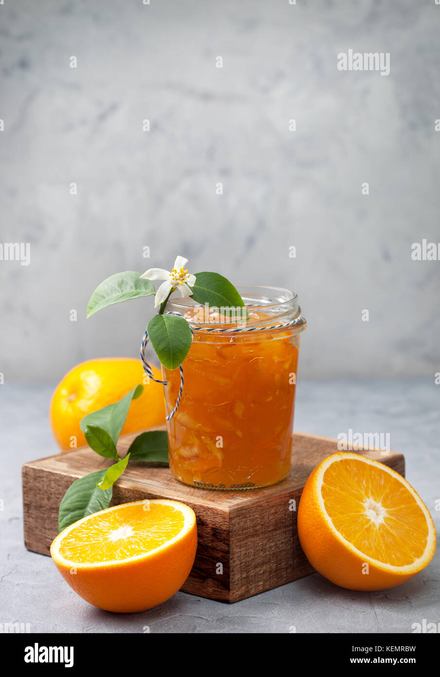 Orange inceppamento in un vasetto di vetro, arance fresche su un cemento grigio sfondo Foto Stock