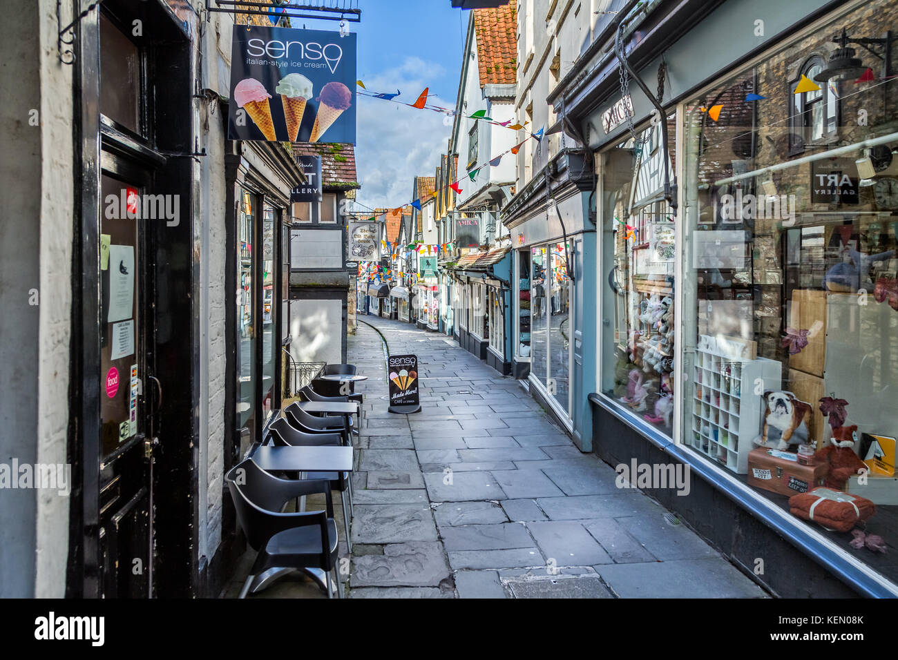 Esecuzione del flusso verso il basso centro medievale di economici street a Frome, somerset Foto Stock