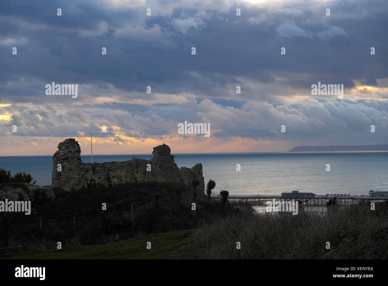 Hastings, East Sussex, 22 ott 2017. In corrispondenza della estremità di coda di tempesta Brian e, dopo una giornata di sole, un ventoso tramonto sul castello di Hastings e con pesanti nuvole temporalesche oltre il lontano Beachy Head. Foto Stock