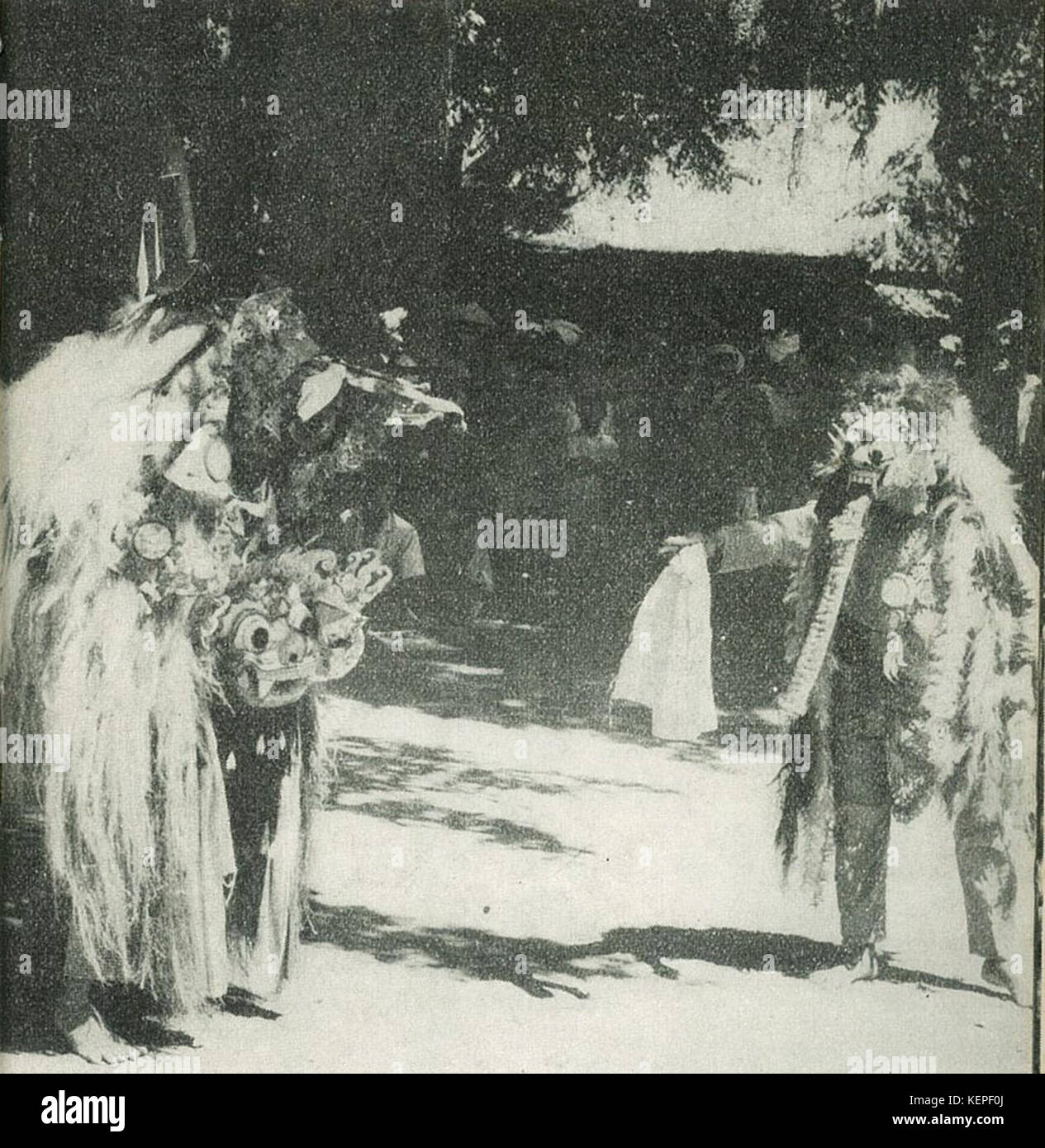 Questa immagine cattura la tradizionale danza balinese barong, simboleggiando la battaglia tra il bene e il male, accanto a una figura di strega. Il barong è un aspetto chiave della cultura balinese e delle sue pratiche spirituali. Foto Stock