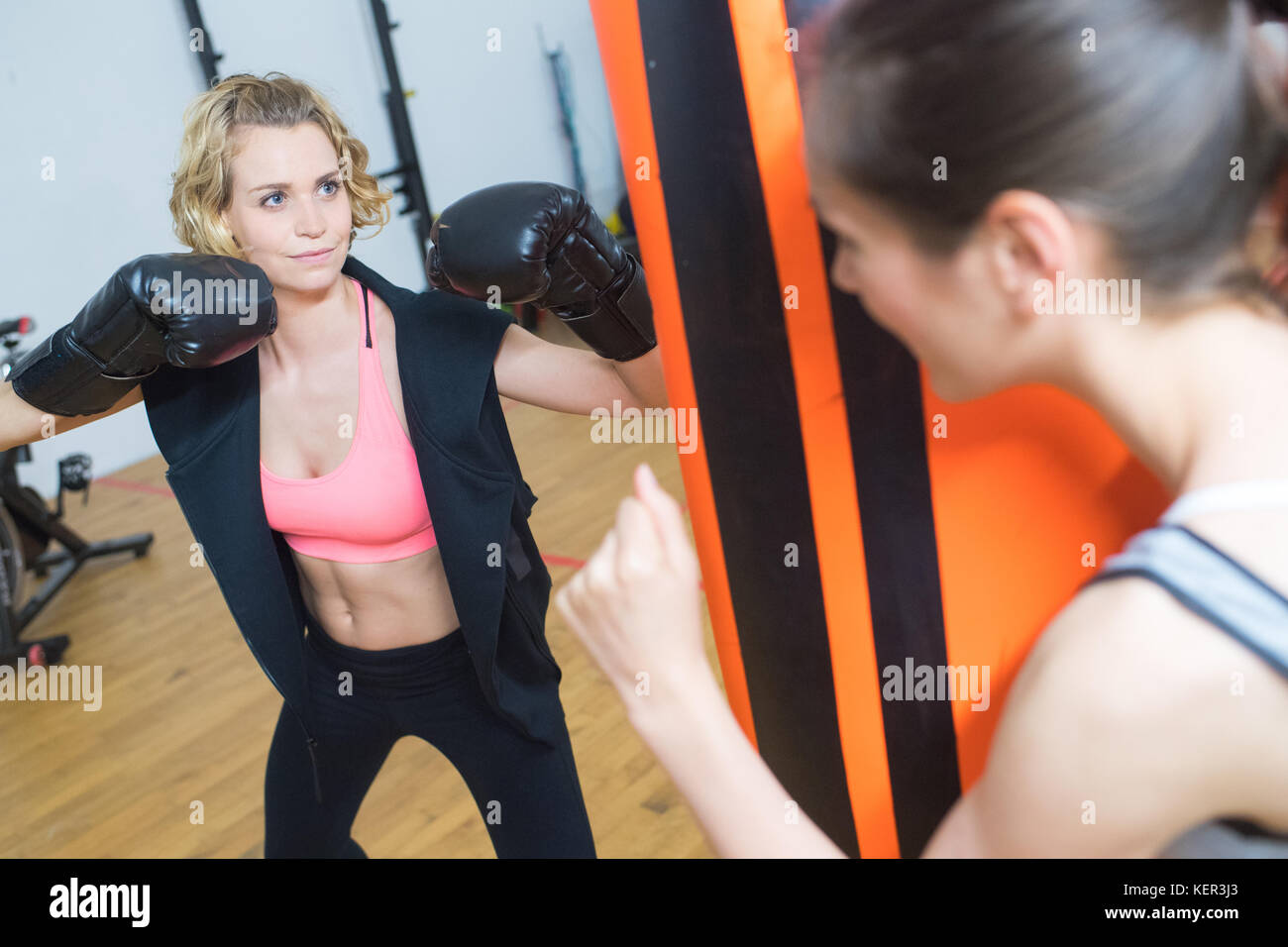 Boxing Trainer femmina sorveglia la boxe studente Foto Stock