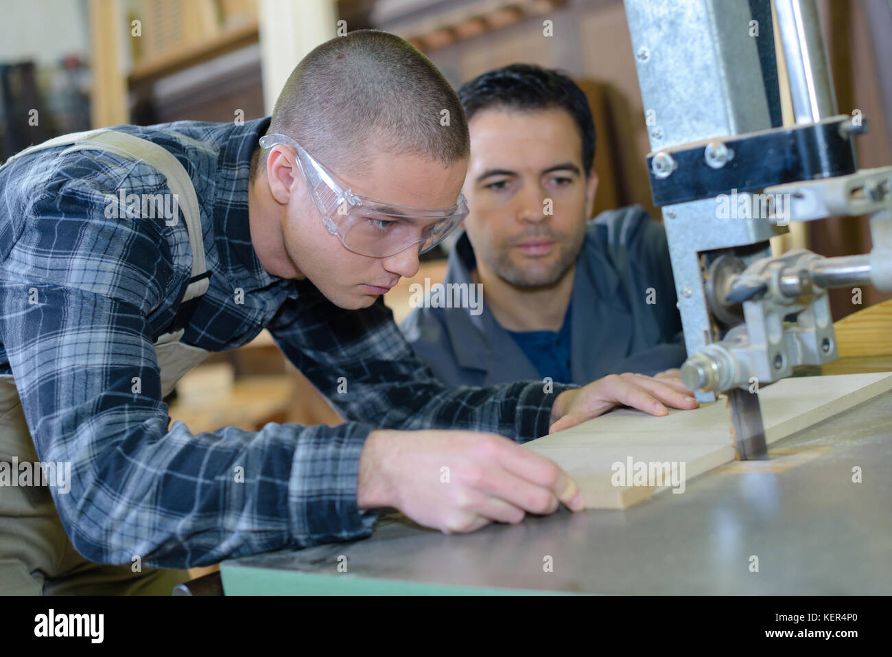 Apprendista con macchina di taglio Foto Stock