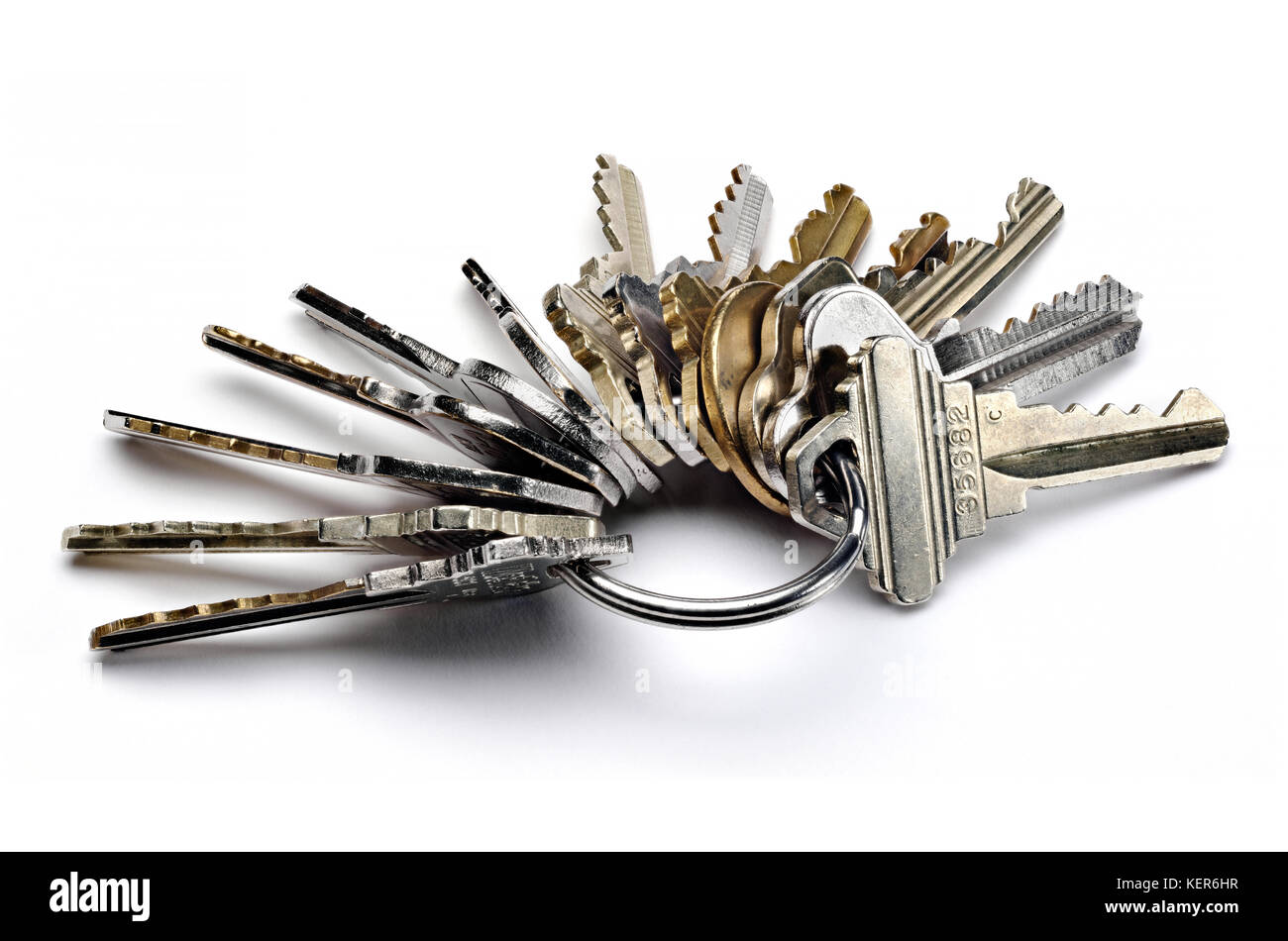 Chiusura del portachiavi di metallo con molti tasti usurati isolato su bianco Foto Stock