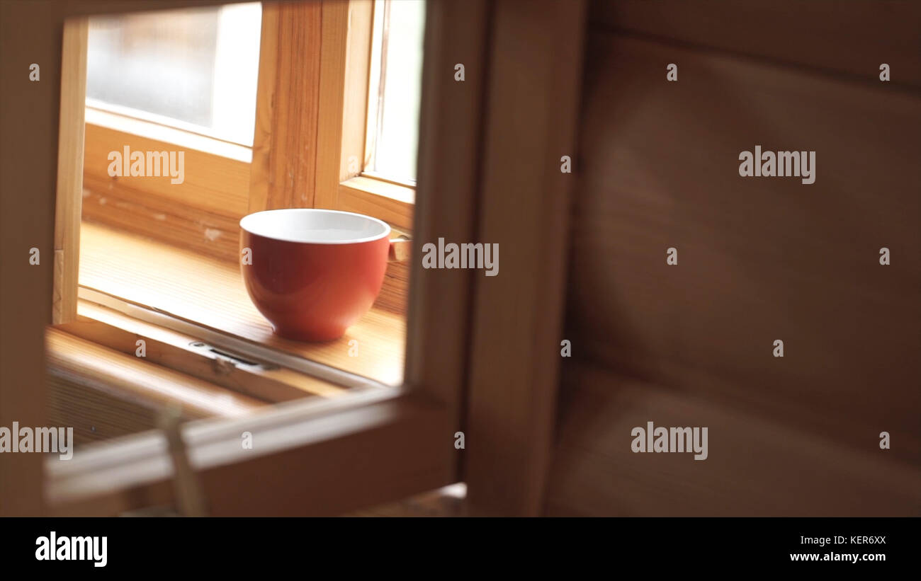 Tazza di tè su un davanzale in legno. Tazza di tè su un davanzale in legno. Fermatevi con una tazza di caffè e vista della città dalla finestra. tazza di tè su un wo Foto Stock