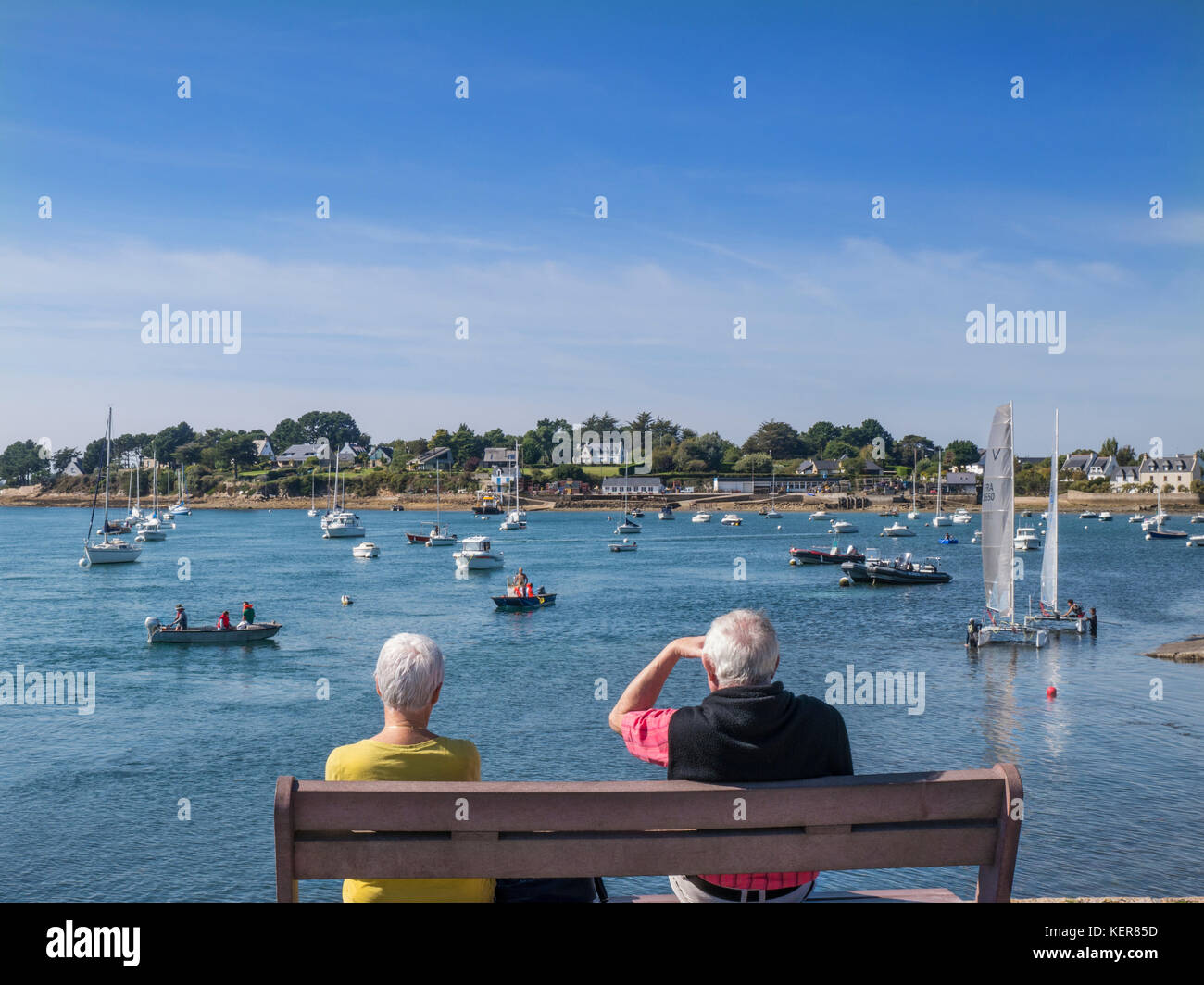 MORBIHAN Sentier de la Plage, coppia seduta guardando varie attività nautiche Golfe du Morbihan, Larmor-Baden, Morbihan, Bretagna, Francia Foto Stock