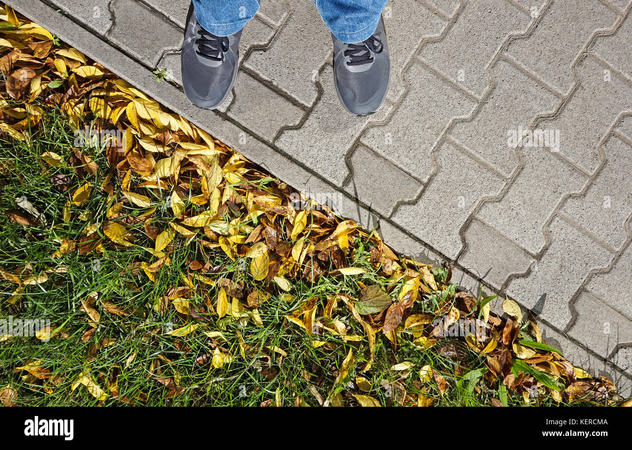 L uomo è in piedi sulla pavimentazione in pietra in autunno Foto Stock