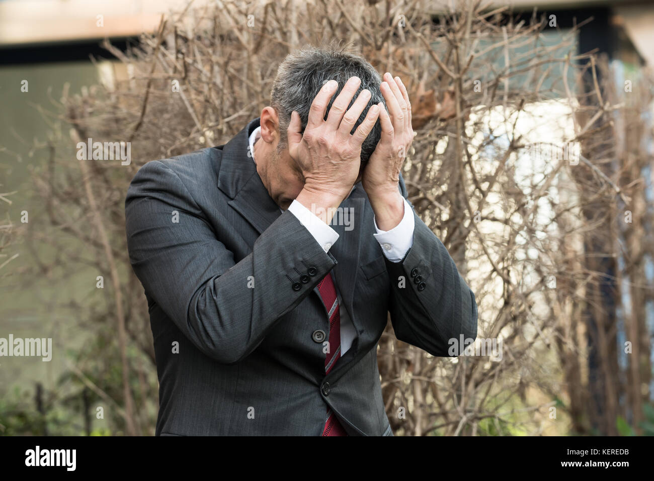 Imprenditore maturo in depressione con le mani sul fronte Foto Stock