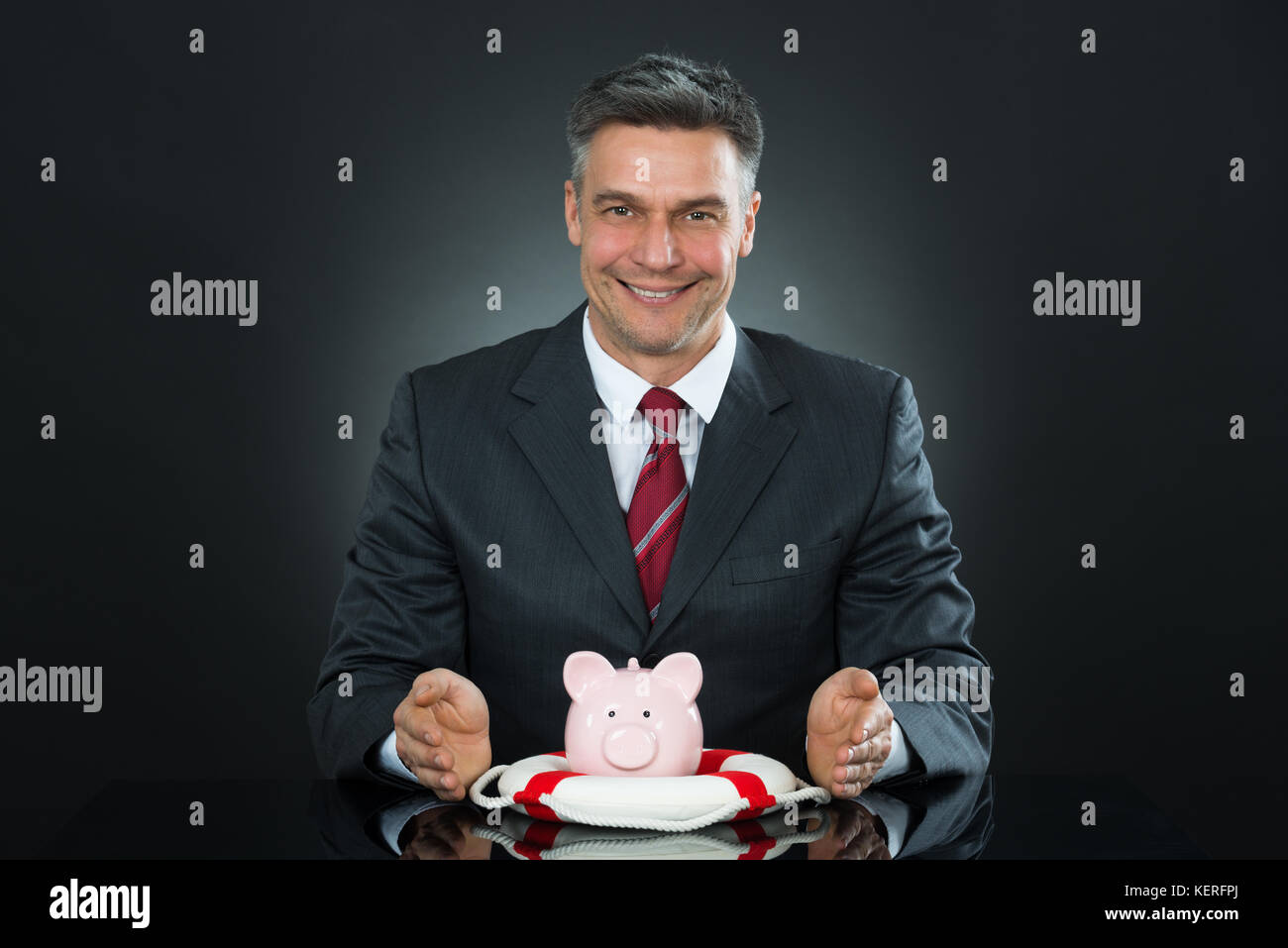 Ritratto di coppia imprenditore proteggere Piggybank con Lifebelt alla scrivania Foto Stock