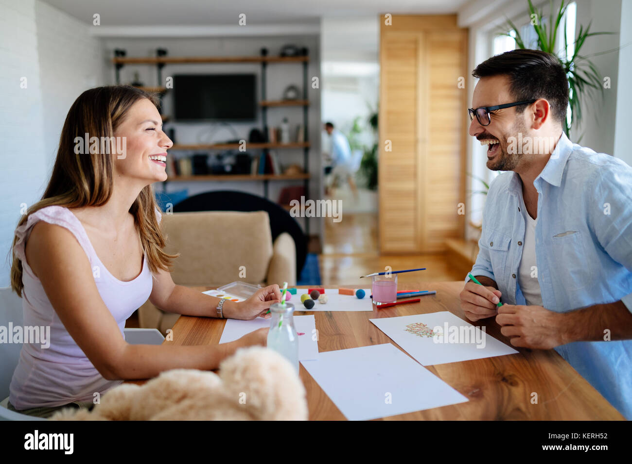 Felice coppia avente il disegno di divertimento a casa Foto Stock