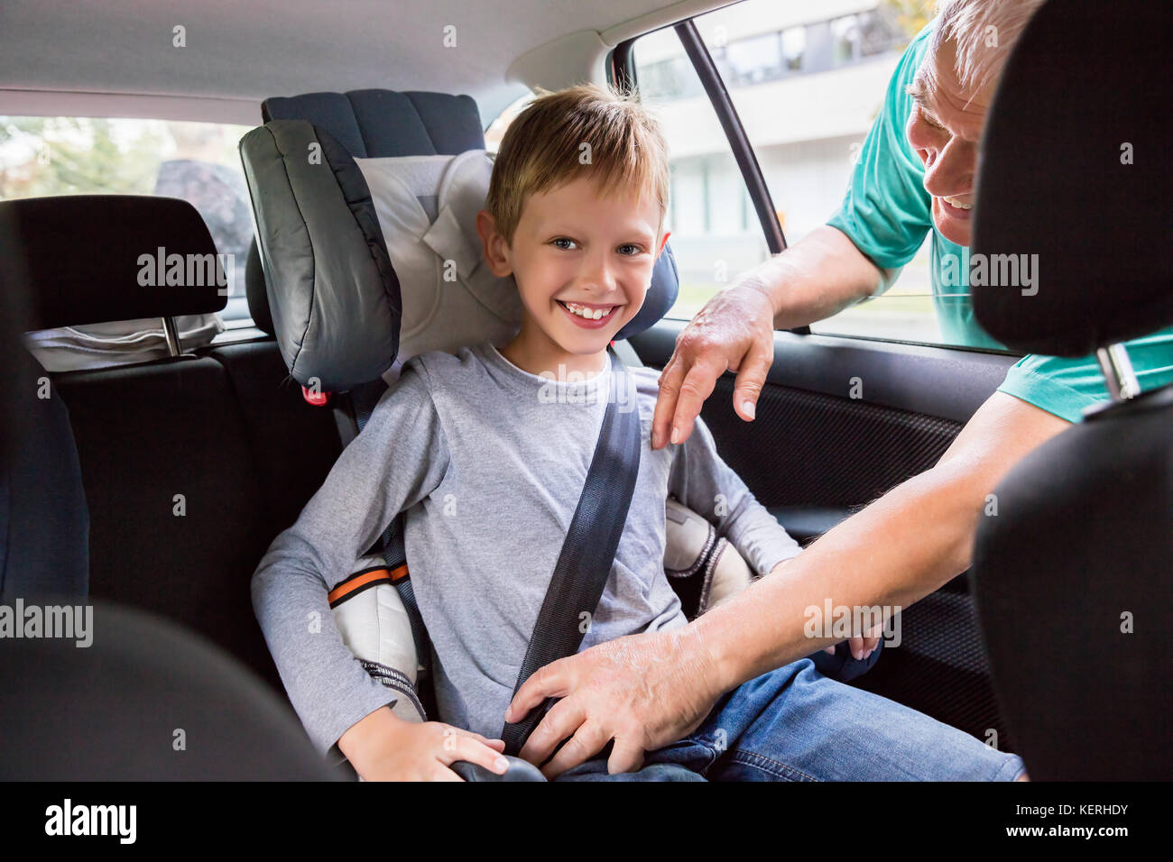 L'uomo Controllo allacciamento della cintura di sicurezza per il bambino  nel seggiolino di sicurezza in auto prima della guida Foto stock - Alamy