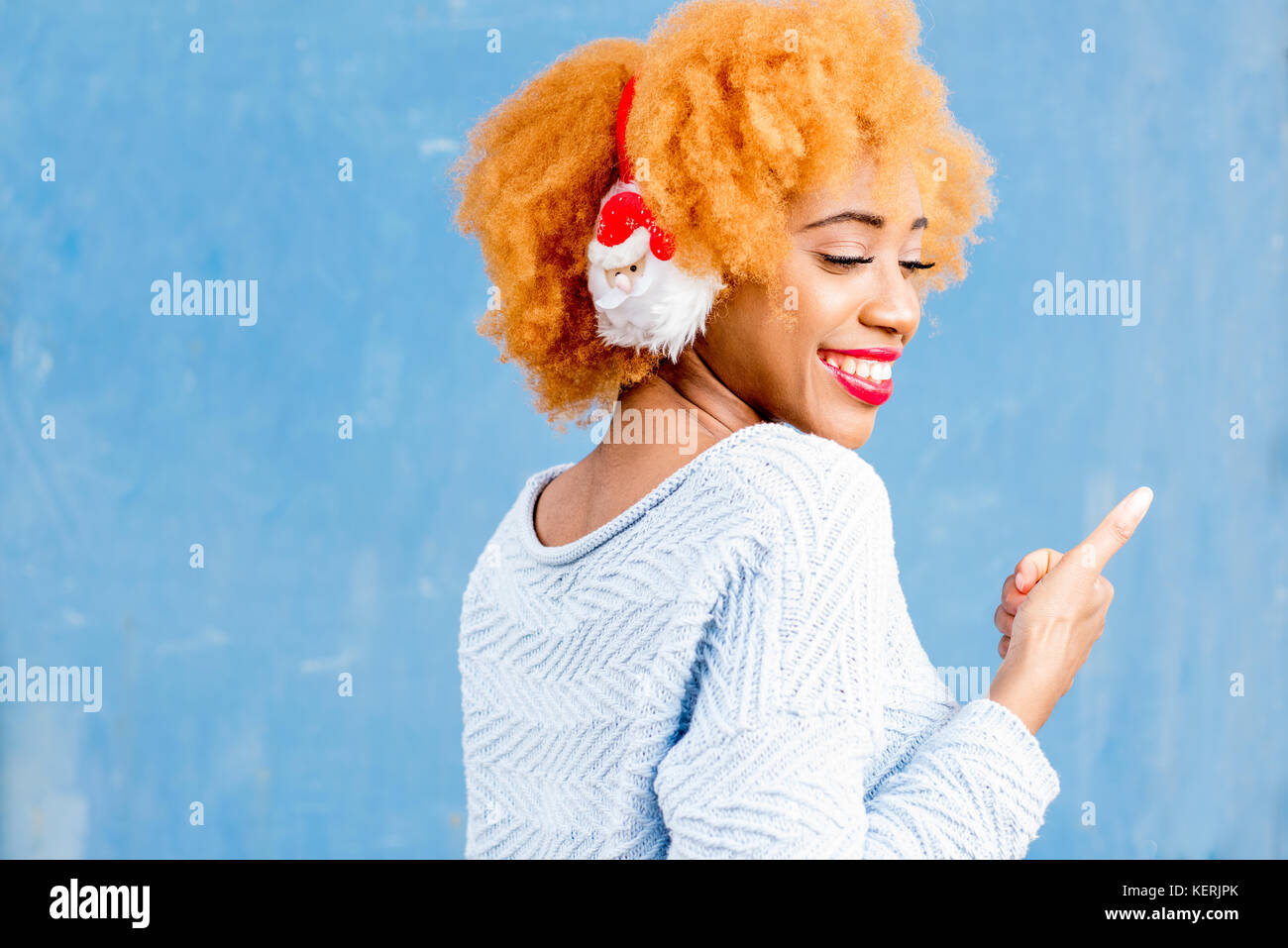 Colorato ritratto di una donna africana in cuffie di natale Foto Stock