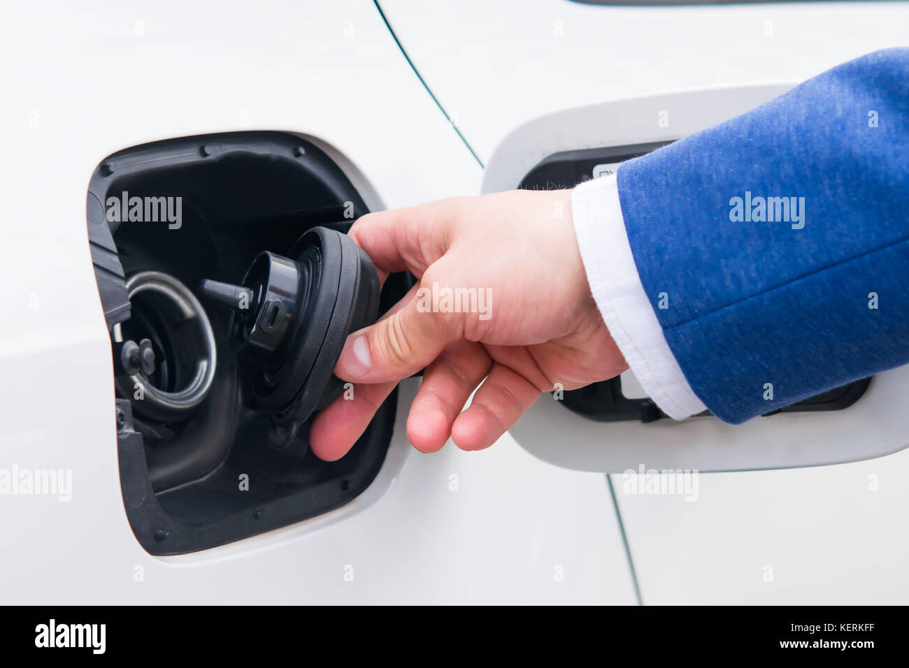 Aprire il coperchio del serbatoio del carburante in auto. il rifornimento di veicoli in corrispondenza di una stazione di gas imprenditore in un vestito Foto Stock