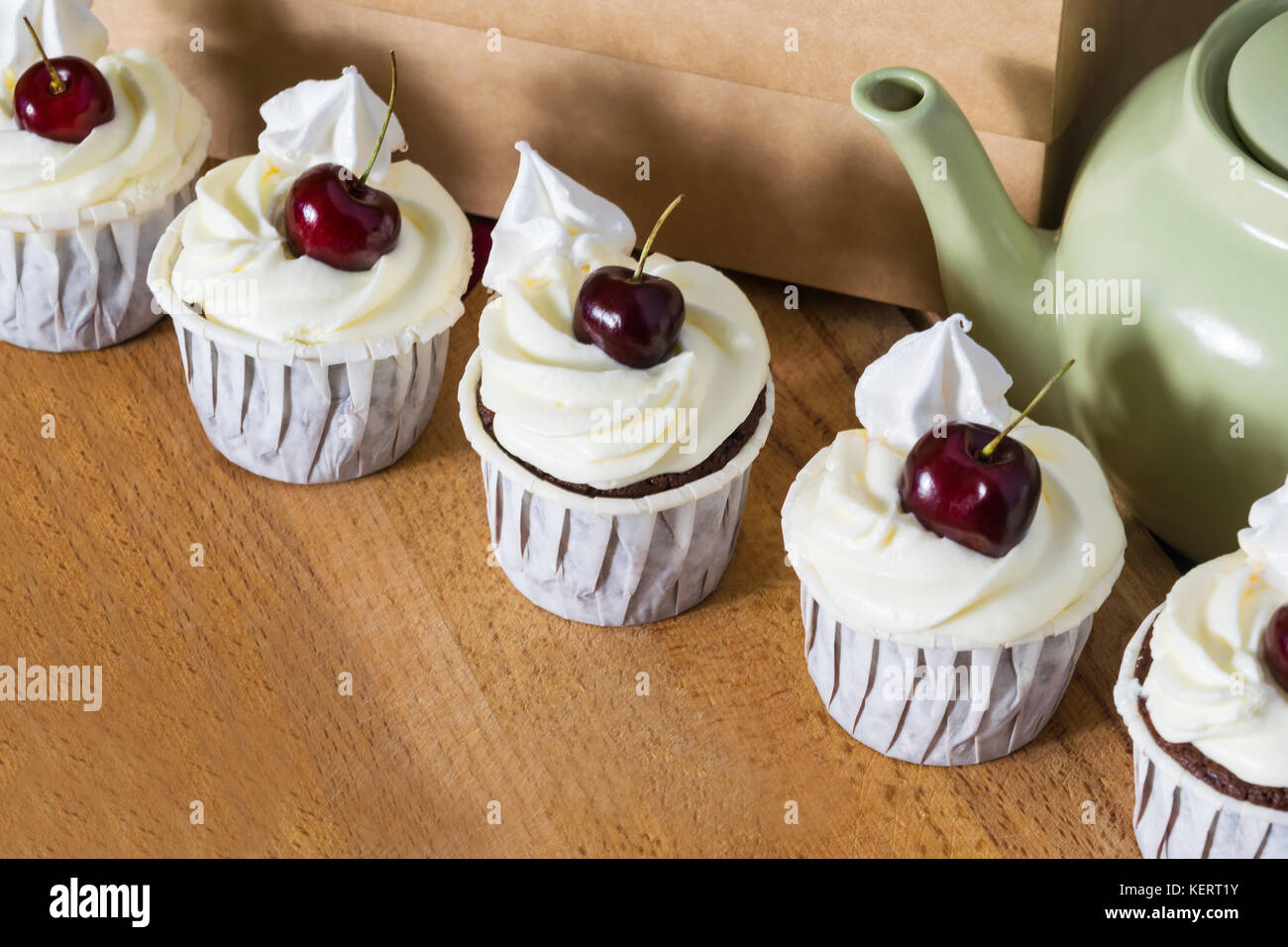 Deliziosi dolci di ciliegia stare accanto a una teiera Foto Stock