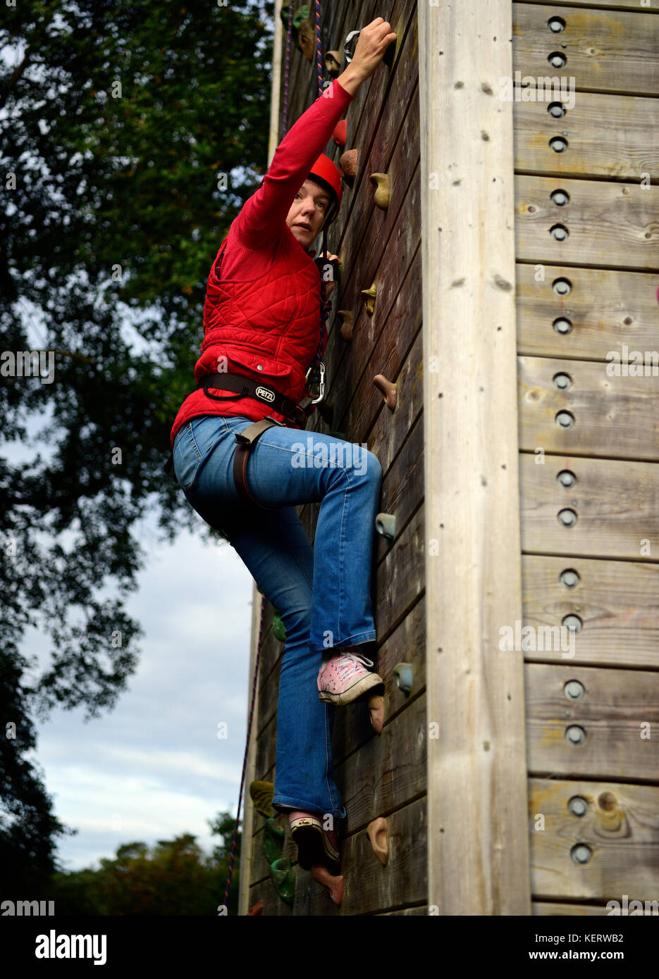Donna con parete di arrampicata per aiutare a raccogliere fondi per un nuovo edificio scout, tilford, vicino a Farnham, Surrey, Regno Unito. Il 30 settembre 2017. Foto Stock