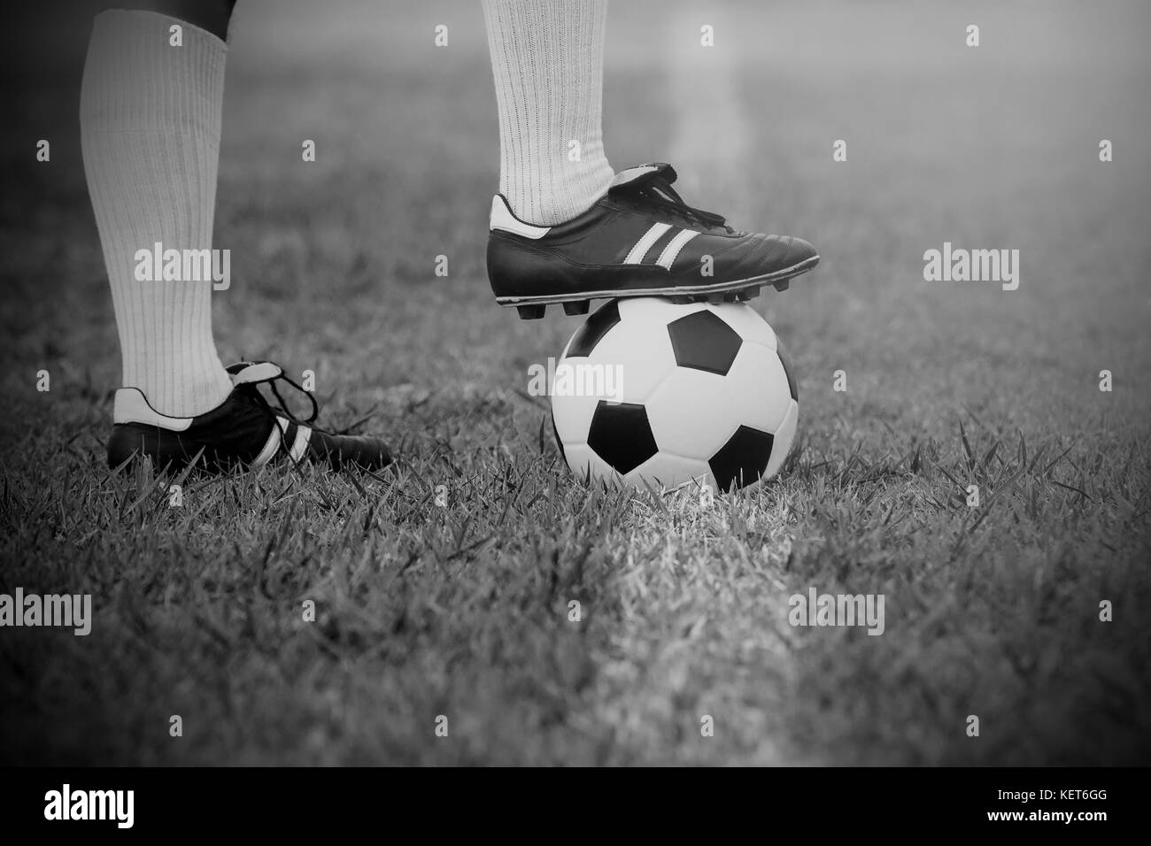 Il calcio o il giocatore di calcio in piedi con la palla sul campo per calciare il pallone da calcio Foto Stock