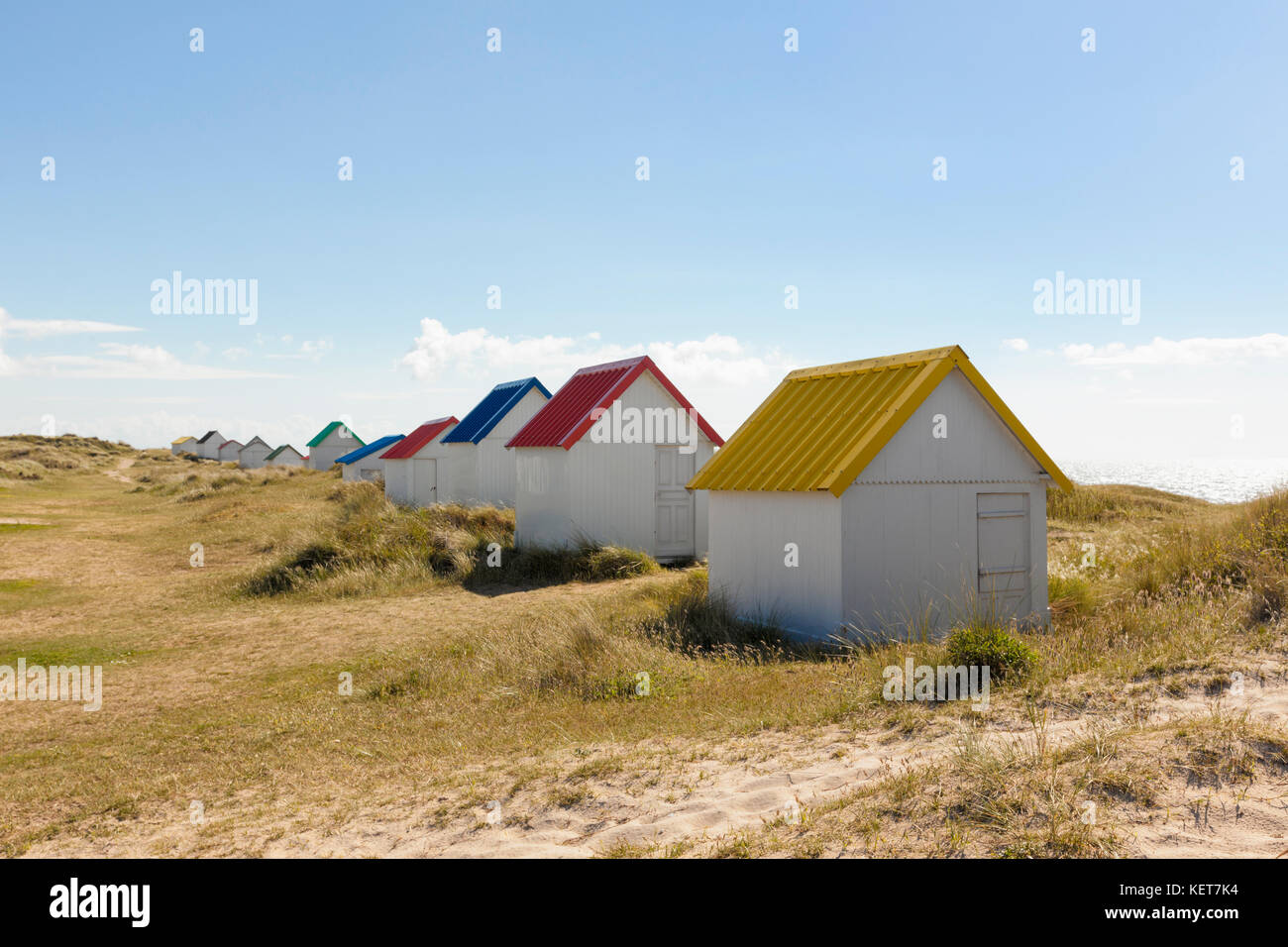 Fila di cabine sulla spiaggia, con tetti colorati a gouville-sur-mer, Normandia, Francia Foto Stock