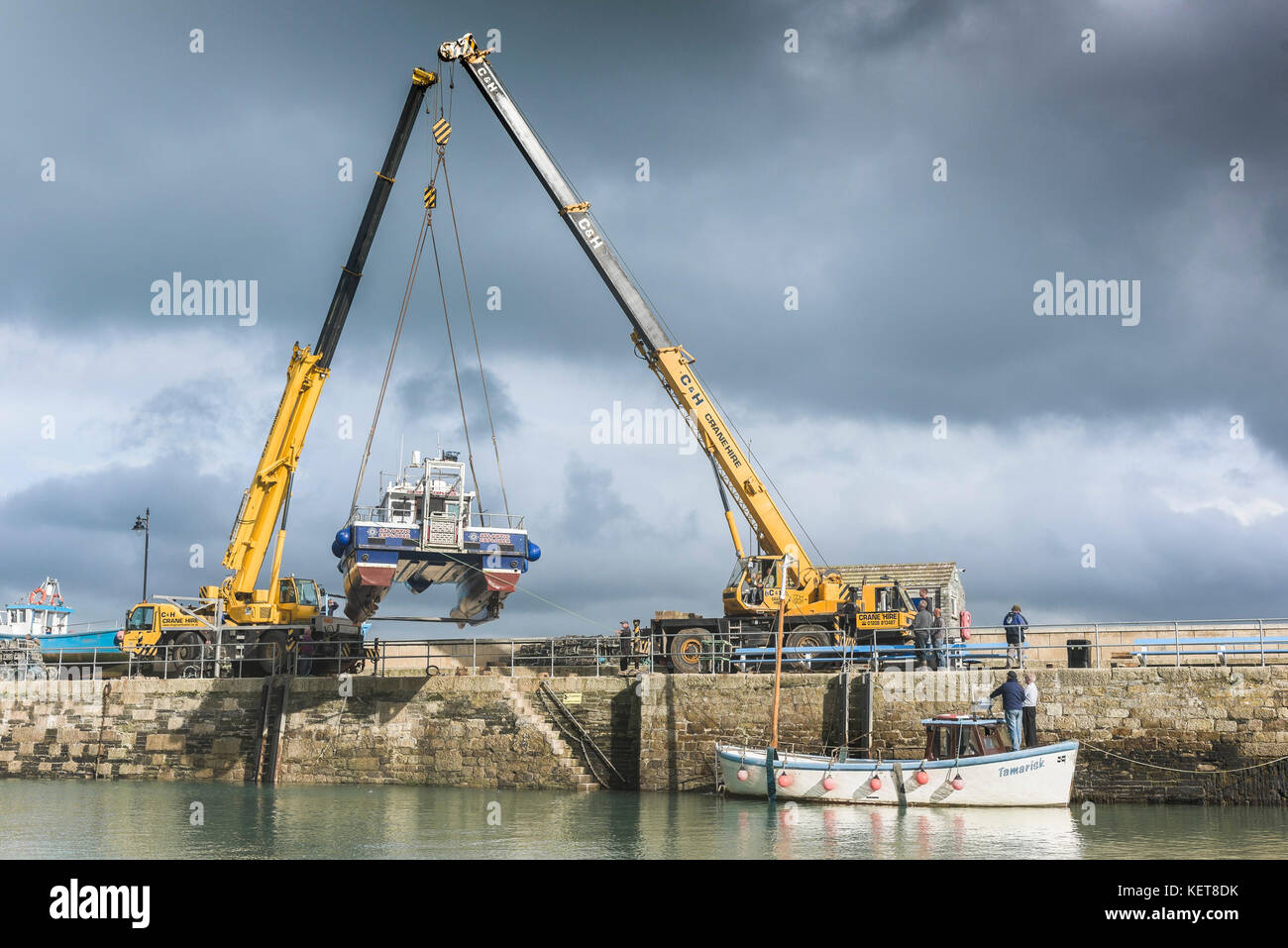 Porto di Newquay Cornwall - una barca essendo allungate fuori di Newquay Harbour per stoccaggio invernale. Foto Stock
