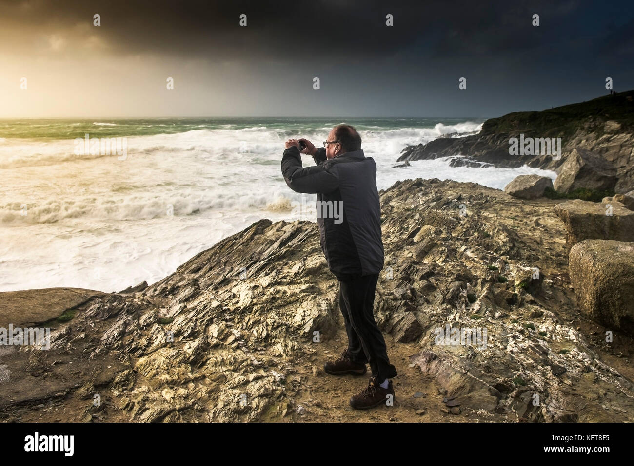 Tempesta Ophelia - un villeggiante che scatta una fotografia del Il mare è tempestoso, mentre Storm Ophelia colpisce la costa a. Newquay Cornwell Foto Stock