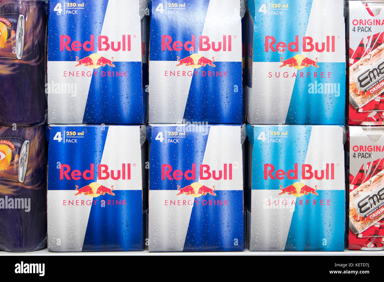 Le lattine di energy drink Red Bull sul display un supermercato scaffale del negozio. Foto Stock