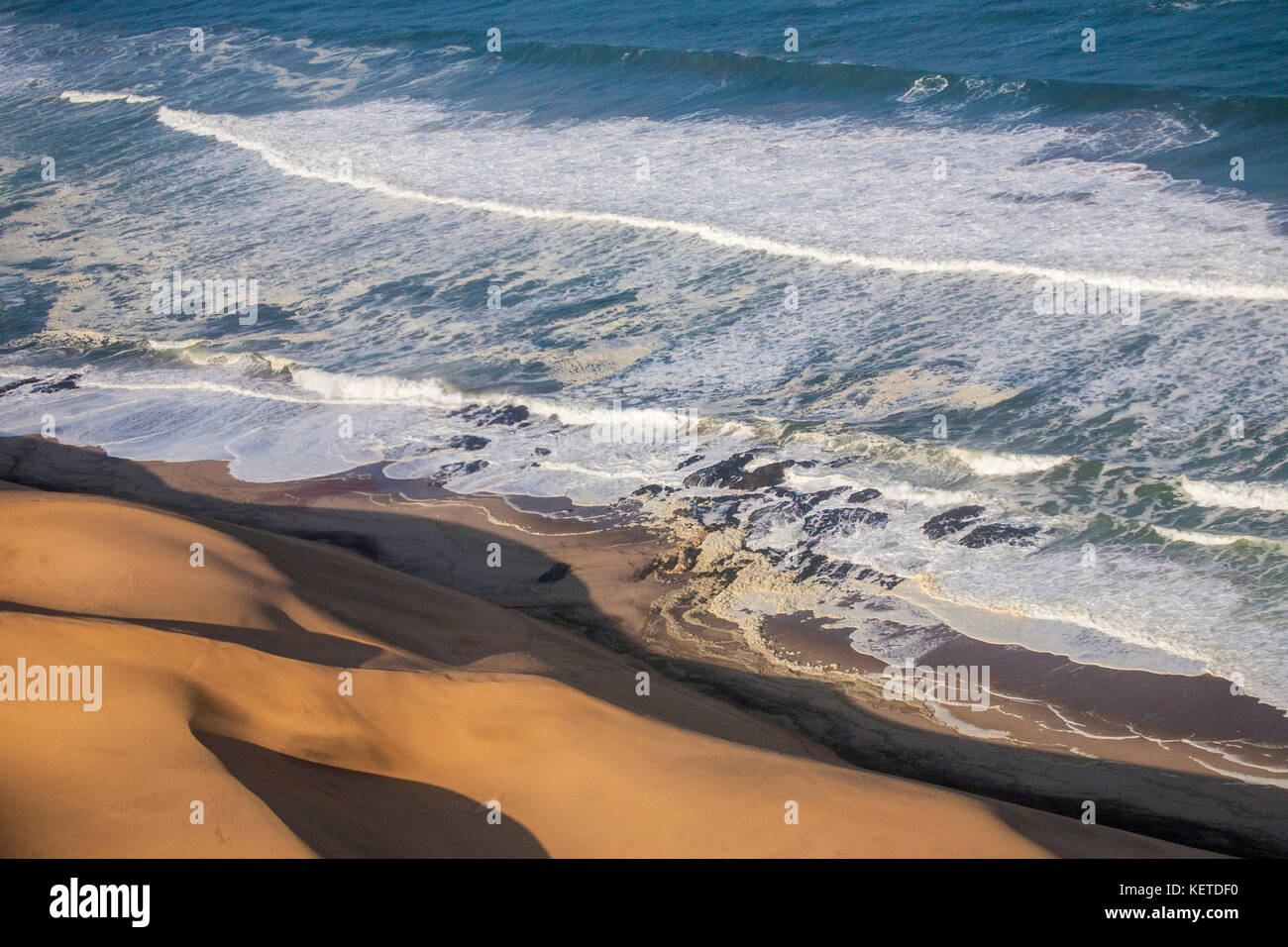 Vista aerea delle onde dell'Oceano Atlantico a schiantarsi contro le dune di sabbia del deserto del Namib namibia Africa australe Foto Stock