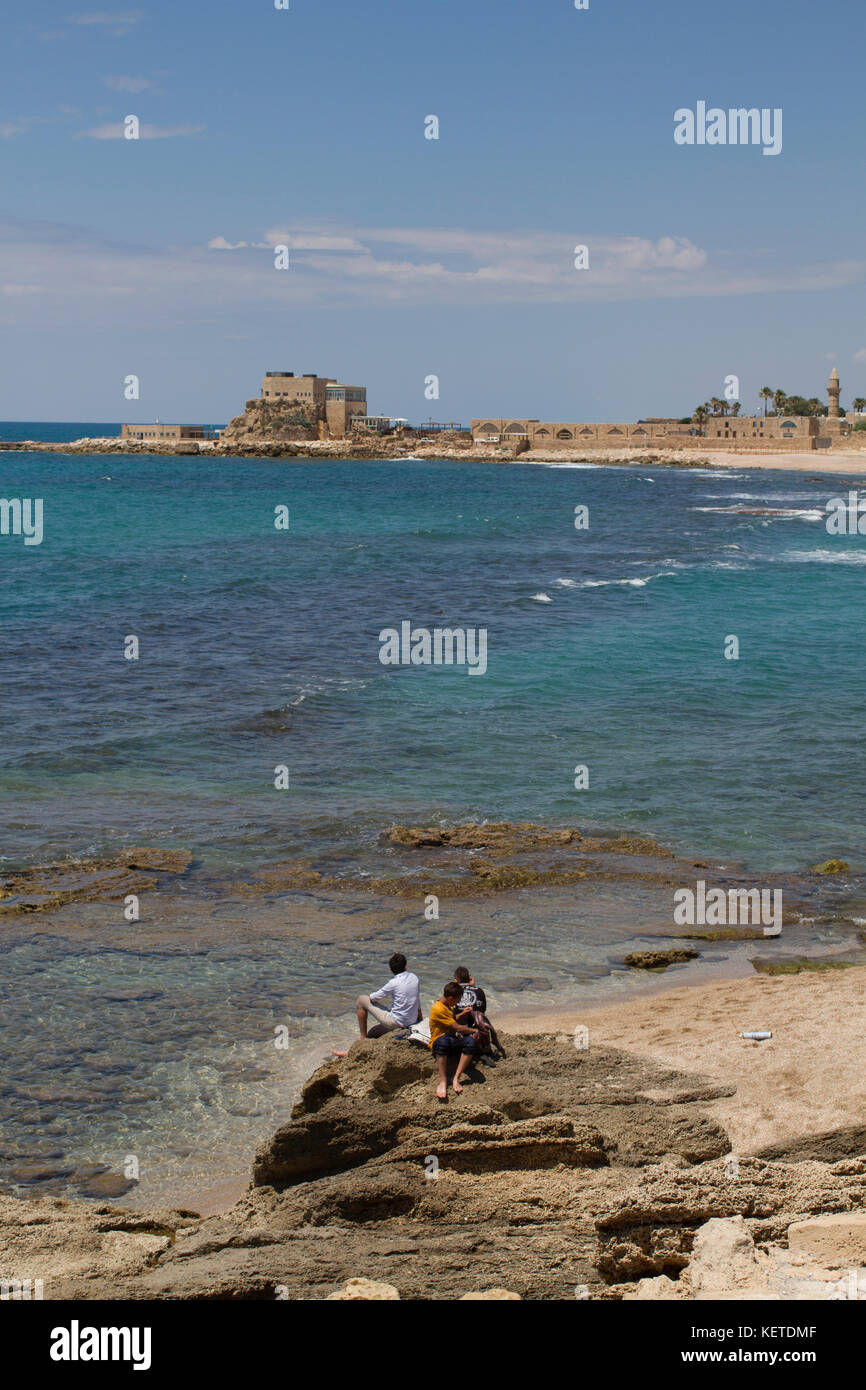 I ragazzi guardano oltre il mare mediterraneo per le antiche rovine di Cesarea, Israele. Foto Stock