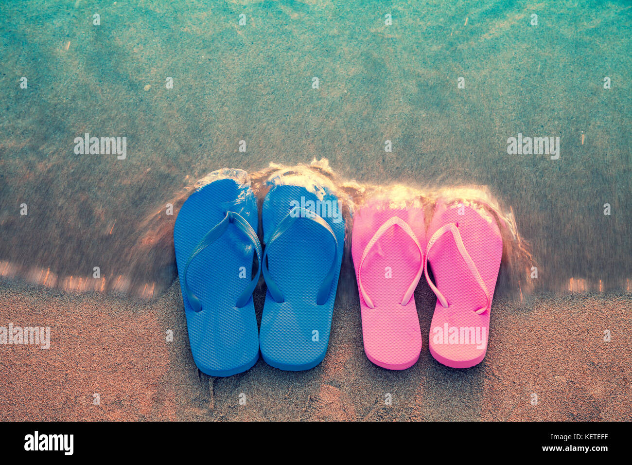 Romantica spiaggia scena. maschi e femmine di flip flop sandals sulla spiaggia Foto Stock