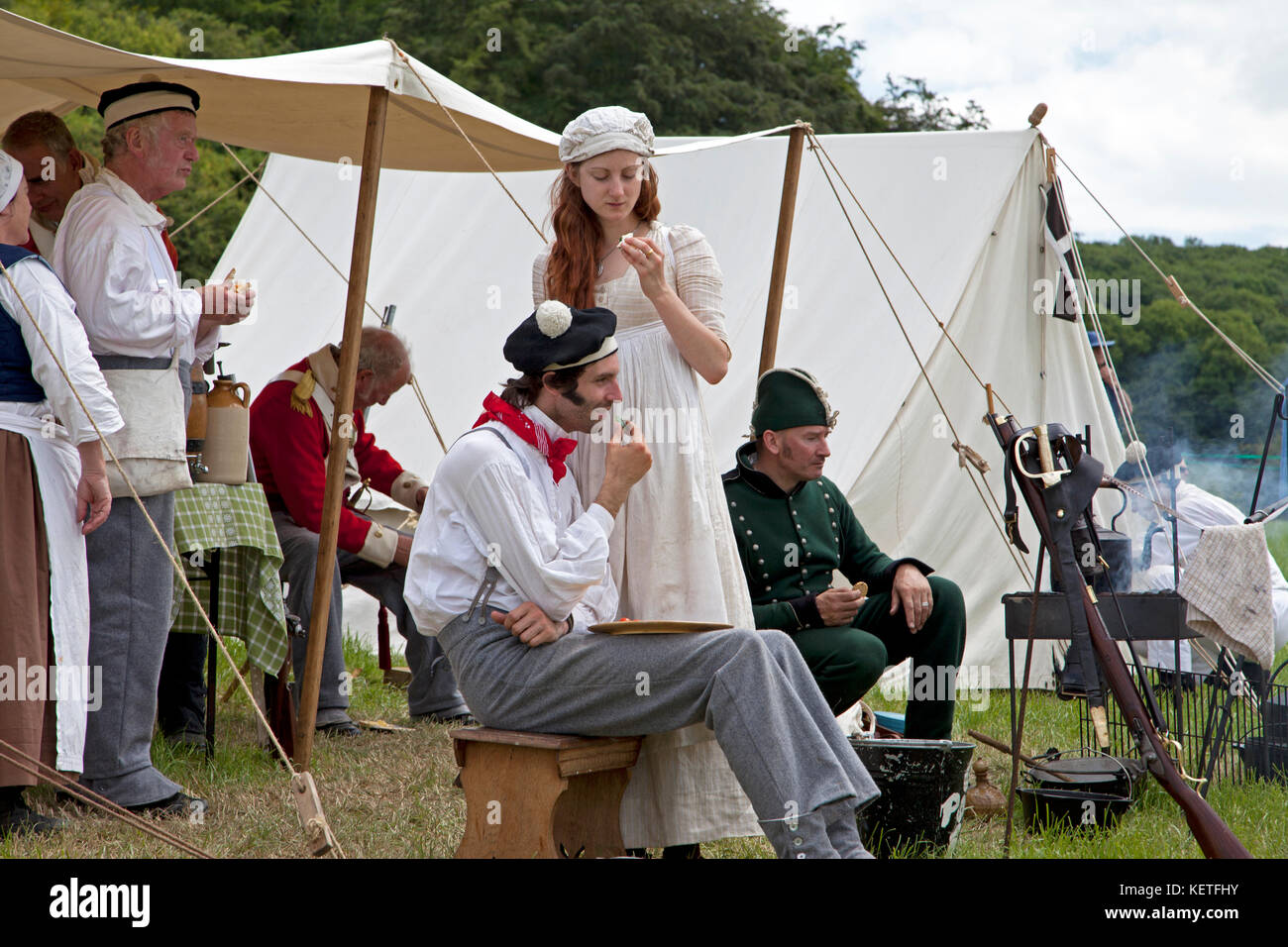 Uomini e donne vestiti con costumi storici che partecipano a un festival di storia. Foto Stock