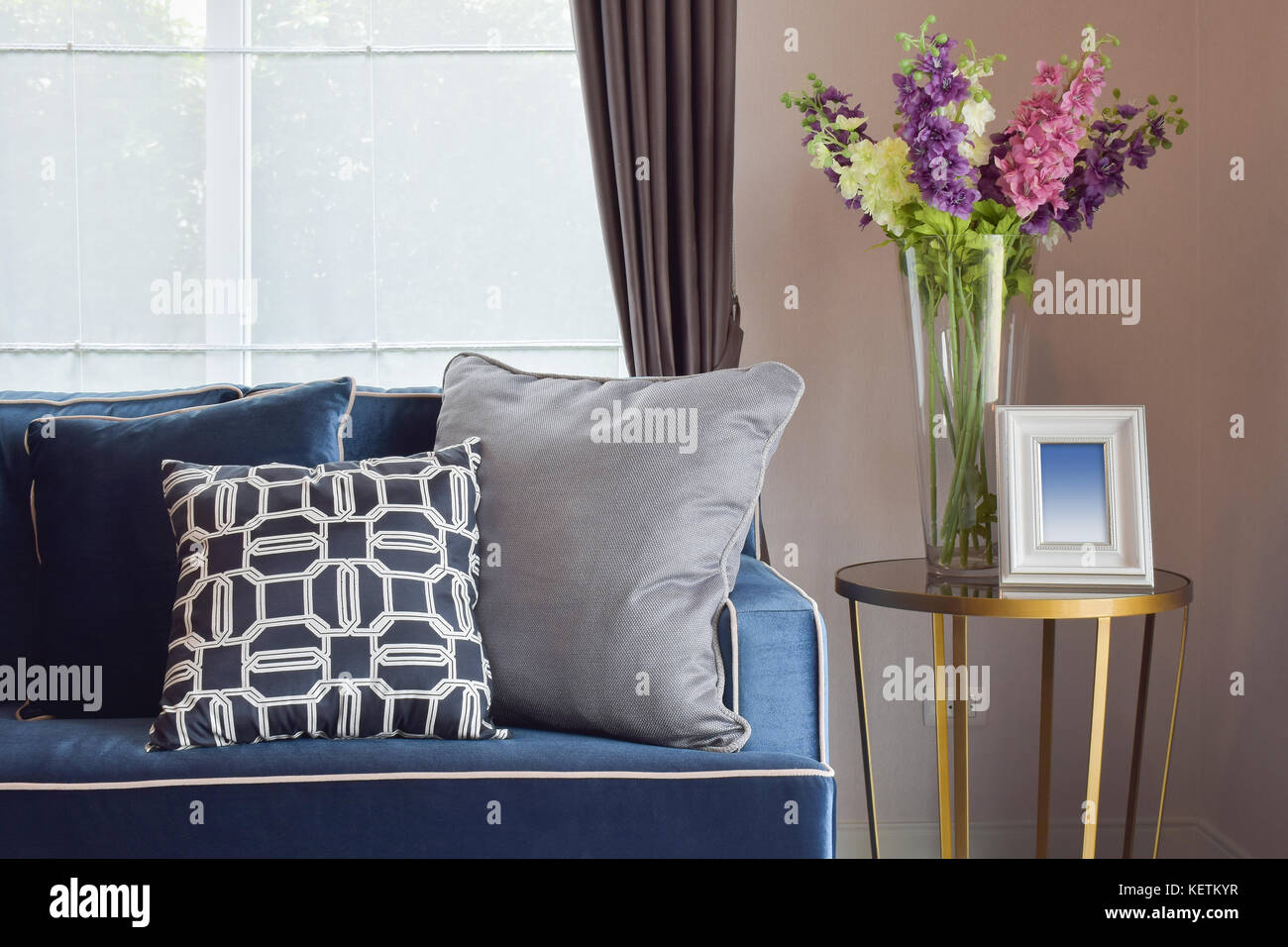 Navy Blue moderno classico divano e retrò, grigio e blu cuscini con un bel  vaso di orchidee sul lato tavolo in angolo soggiorno Foto stock - Alamy