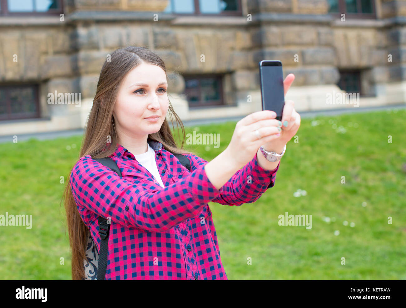Giovane donna con capelli lunghi utilizza lo smartphone in unione città vecchia Foto Stock